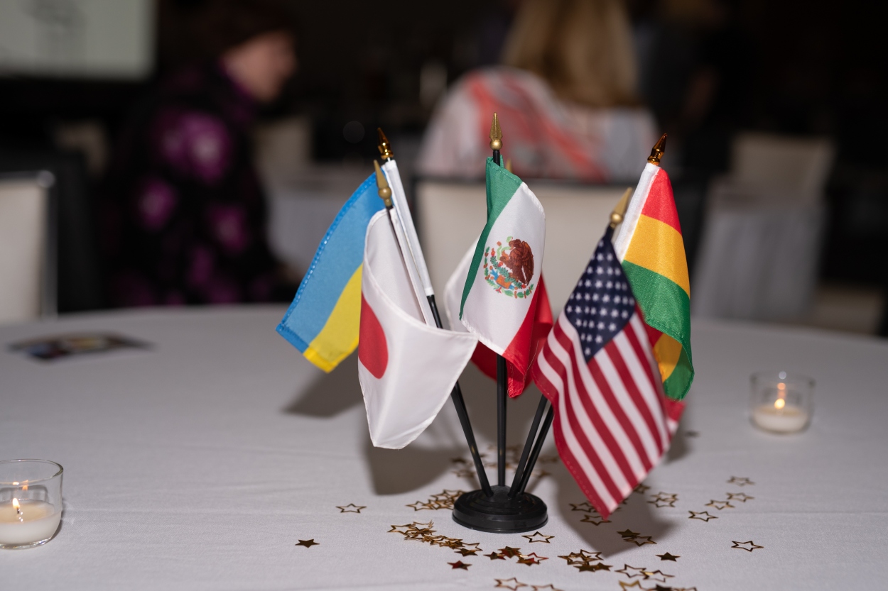 Several flags representing the Grand Rapids Sister Cities rest on a table